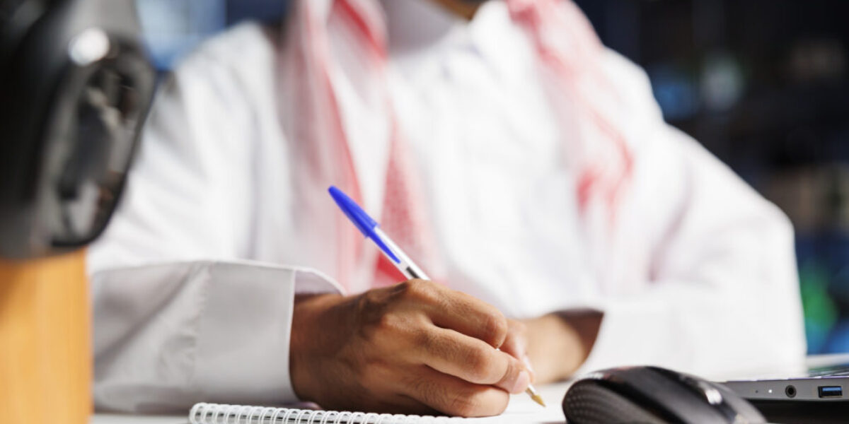 Muslim guy writing down research notes